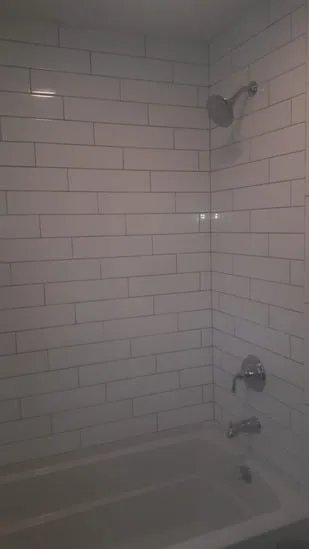 Subway tile shower installation showing aligned tile layout around fixtures.